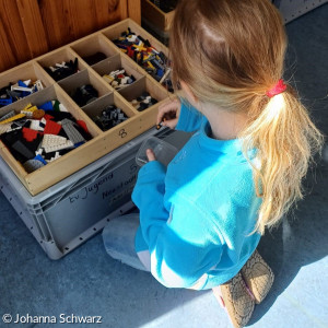 Kind spielt mit Legosteinen